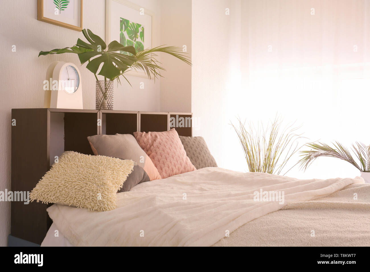 Confortevole camera matrimoniale con verde foglie tropicali Foto Stock