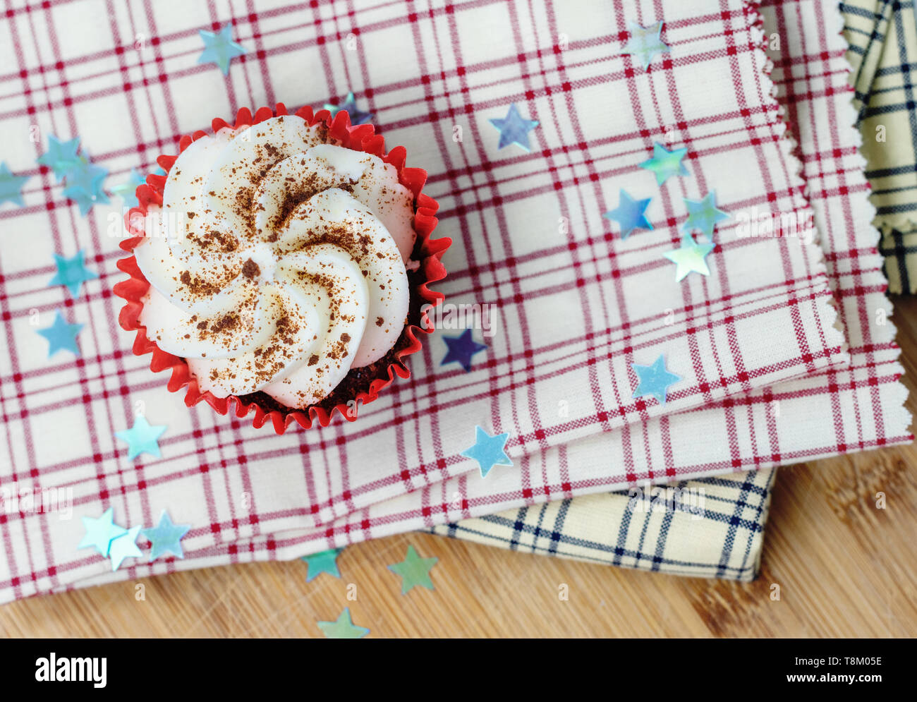 Red Velvet cupcake su plaid tessuto decorativo con stelle e una profondità di campo ridotta Foto Stock