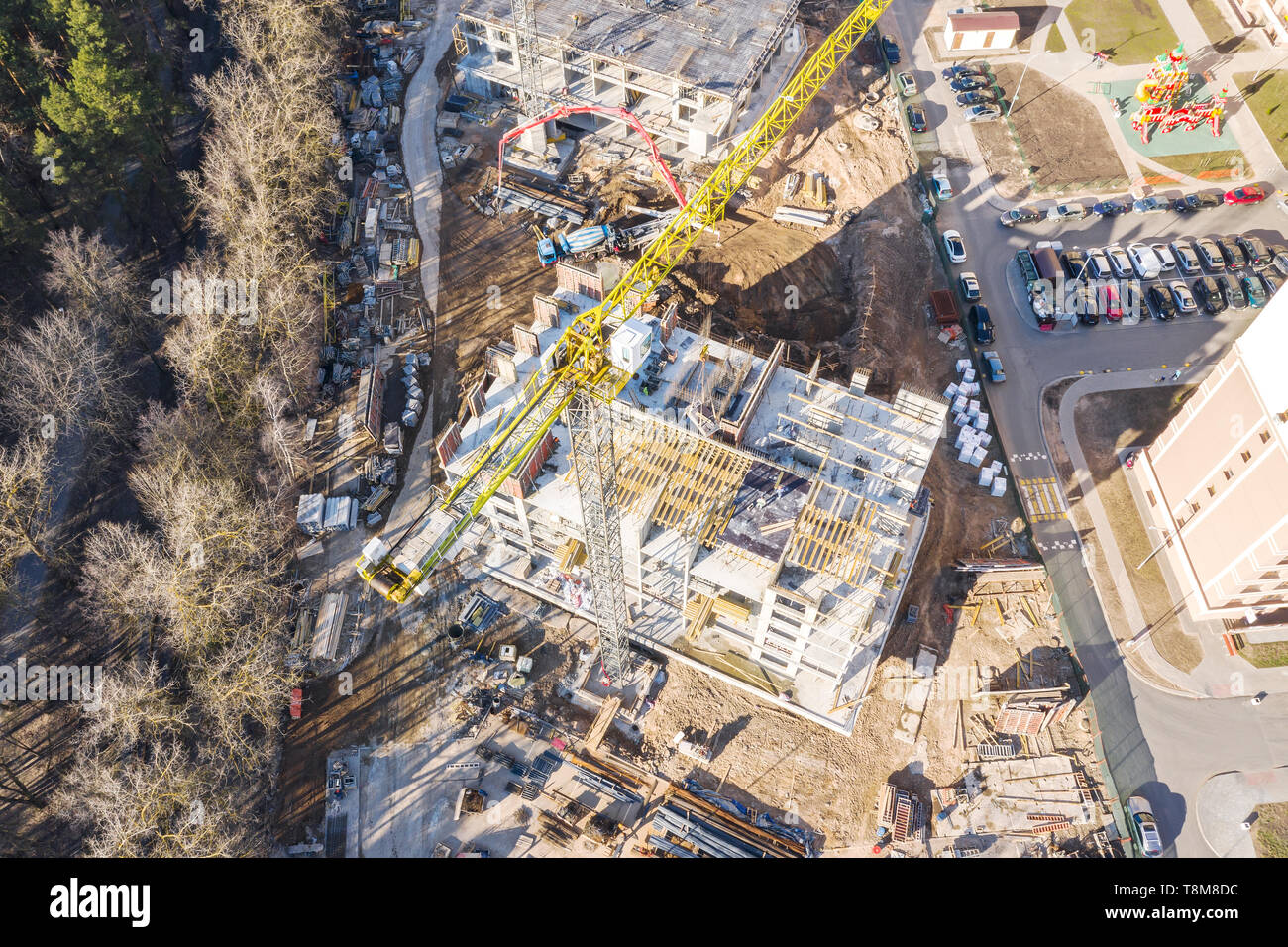 Vista superiore della costruzione della città sito con alto giallo gru a torre. lo sviluppo delle infrastrutture della città. drone fotografia Foto Stock