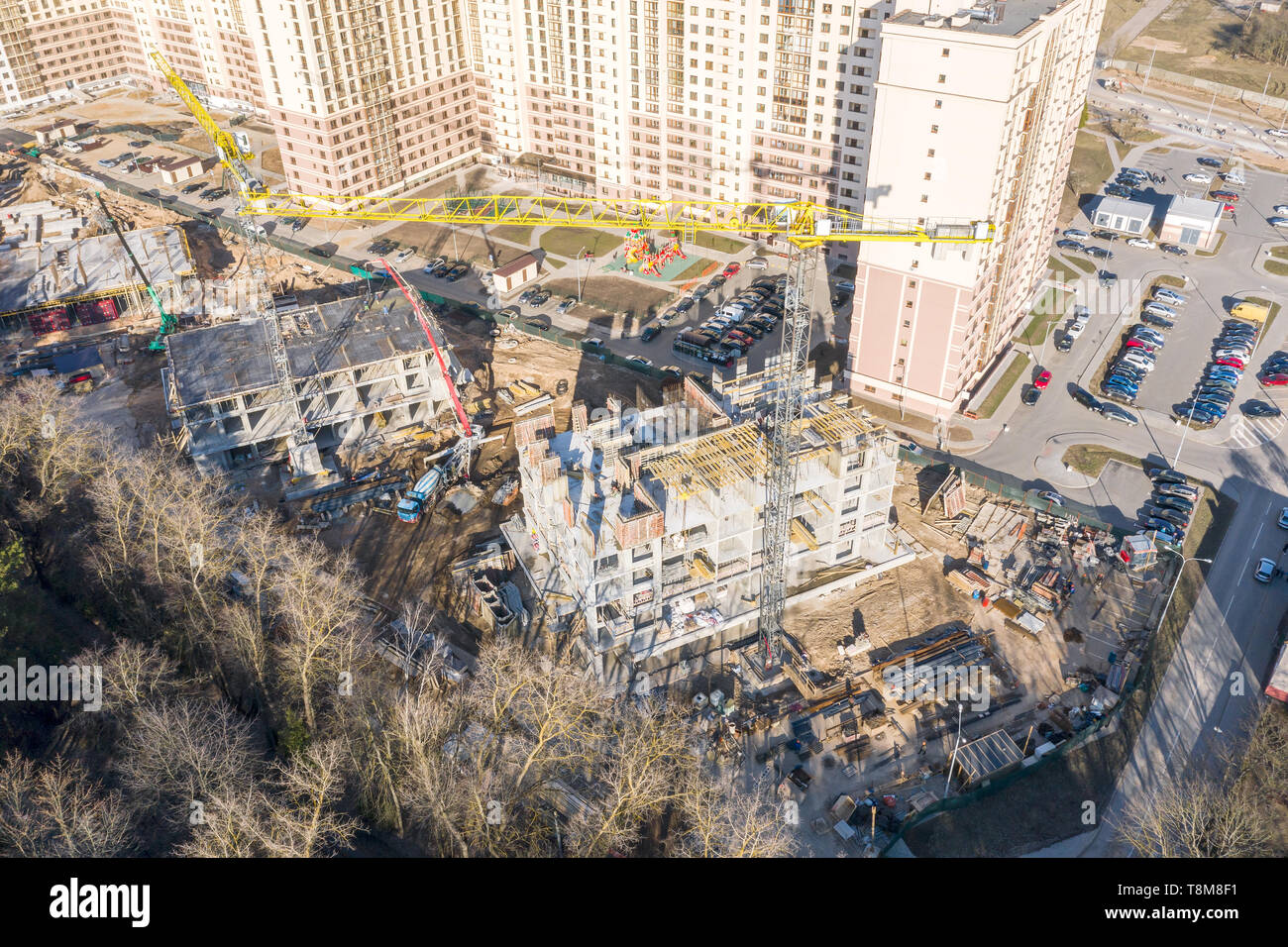 Vista aerea della città sito in costruzione. gru a torre vicino alla metà costruiti edifici. drone fotografia Foto Stock