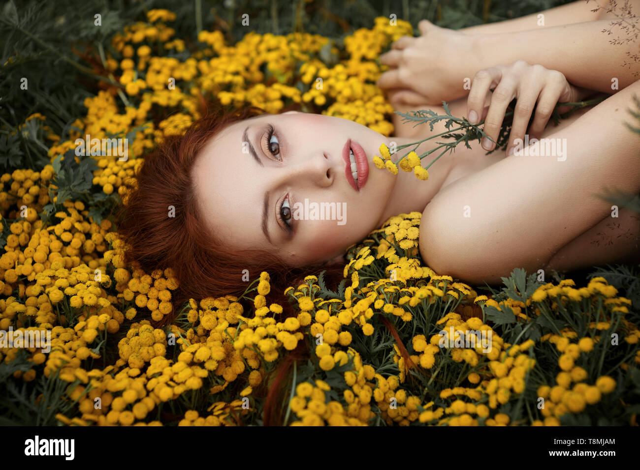 Ritratto di una ragazza distesa di fiori Foto Stock