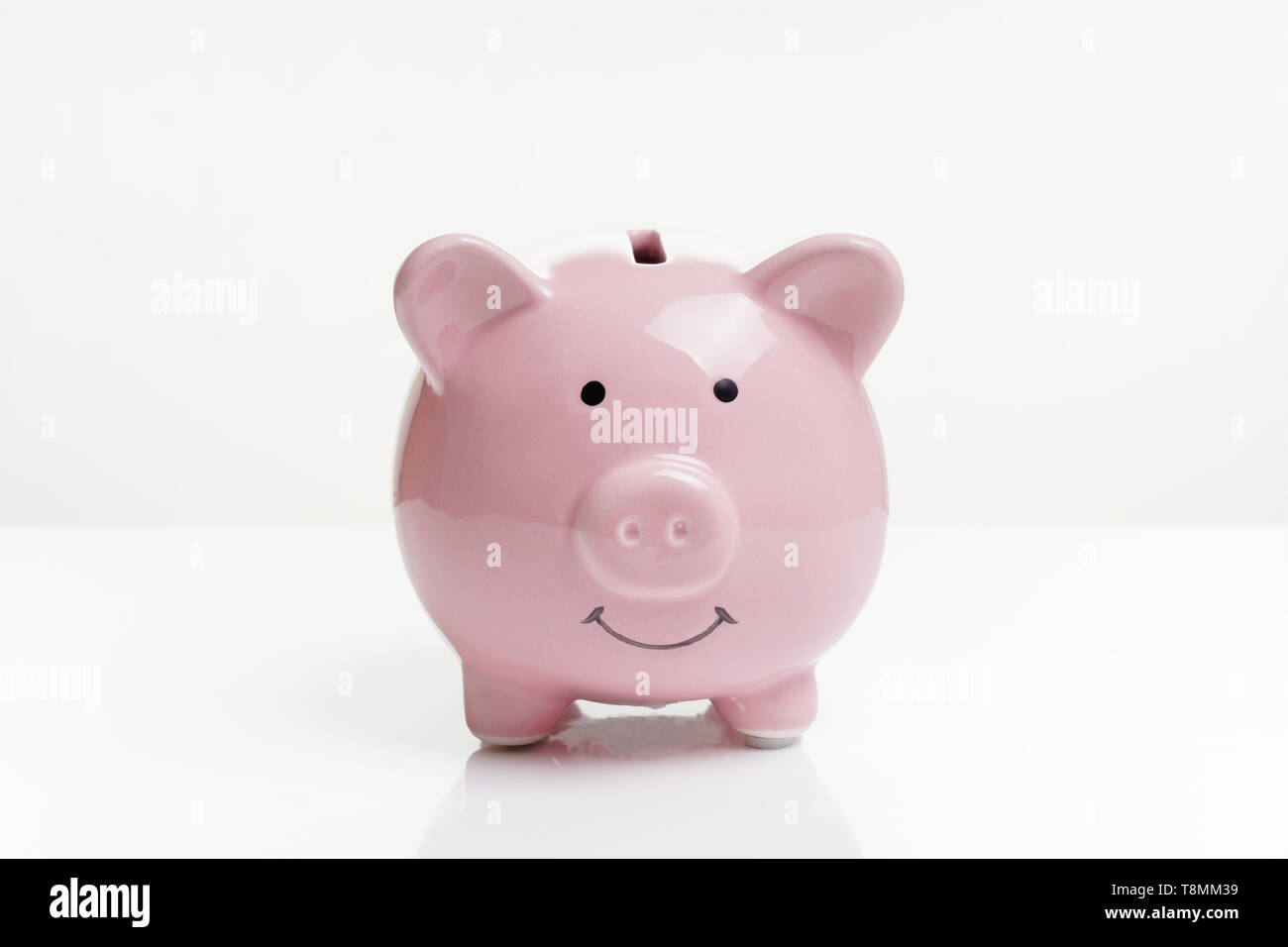 Piggy o moneta della banca o piggybank o casella di denaro - Finanza e concetto di risparmio su sfondo bianco con la riflessione Foto Stock