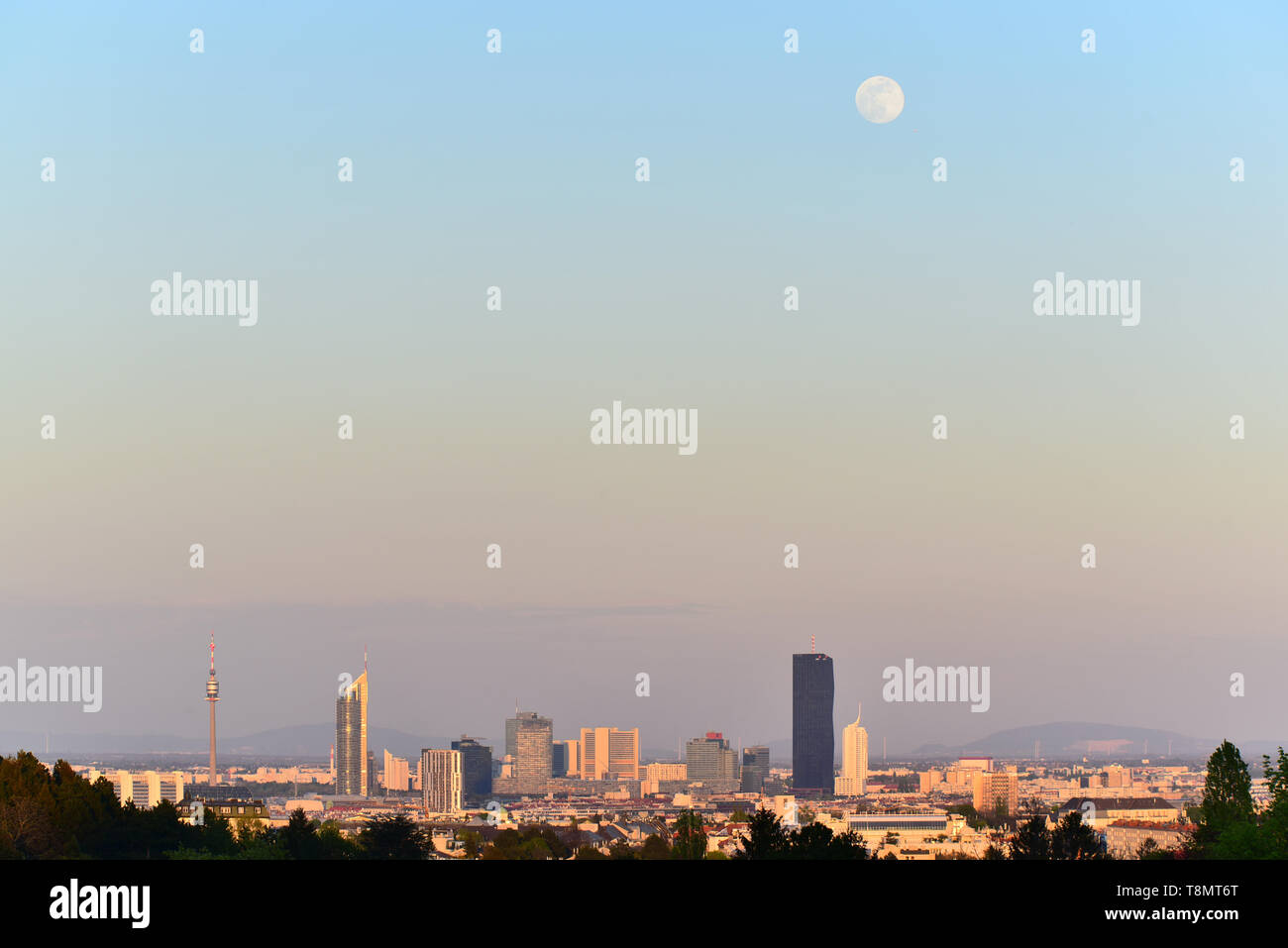 Luna su grattacieli in scena serale del Centro internazionale di Vienna e uno scenario urbano. Foto Stock