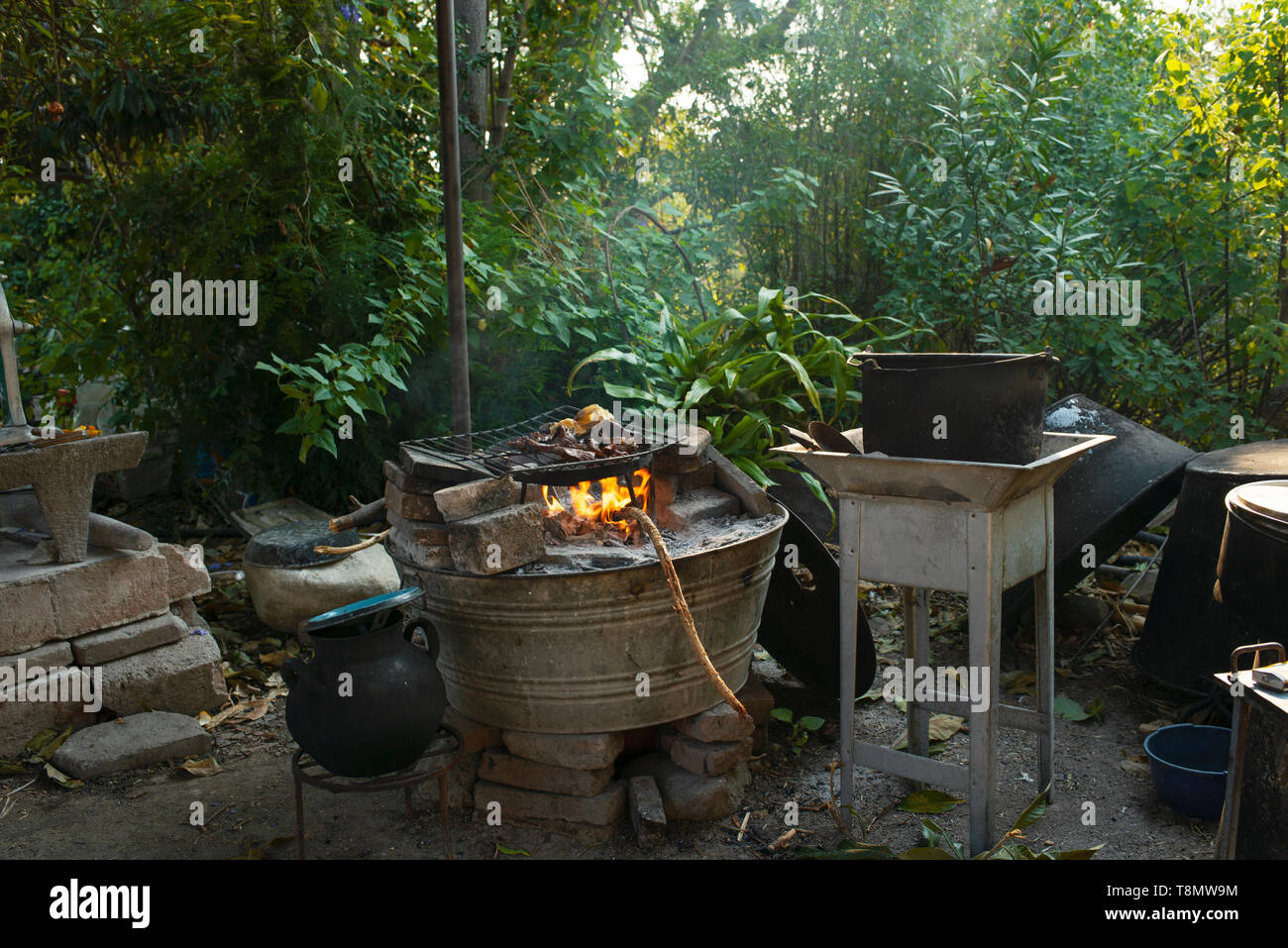 Cucina esterna con la carne viene arrostito su un fuoco aperto. Teotitlan del Valle, Stato di Oaxaca, Messico. Apr 2019 Foto Stock