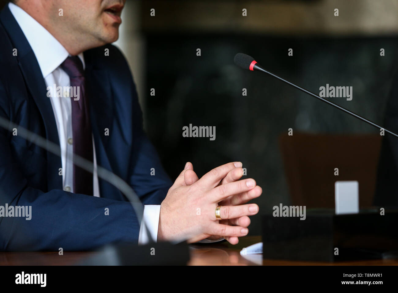 Dettagli con le mani di un uomo in tuta (imprenditore, CEO, politico) Tenendo un discorso in un microfono Foto Stock
