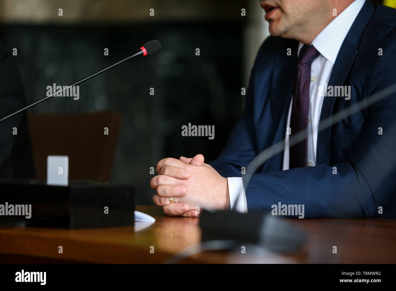 Dettagli con le mani di un uomo in tuta (imprenditore, CEO, politico) Tenendo un discorso in un microfono Foto Stock