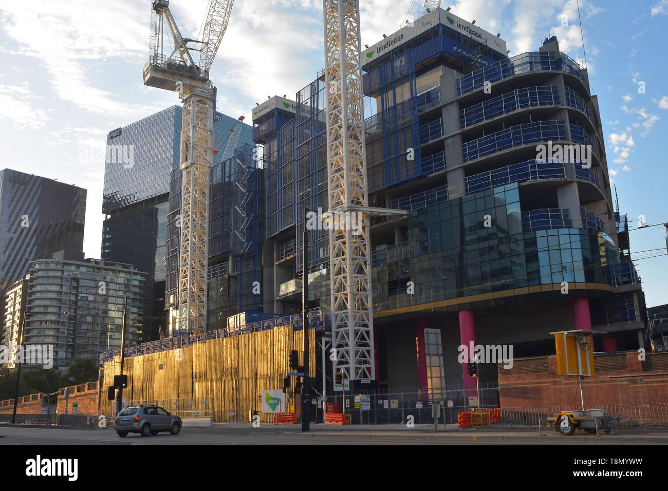 Sito in costruzione con due gru a torre di città di edificio con scheletro di cemento coperto con lastre di vetro nei telai metallici. Foto Stock