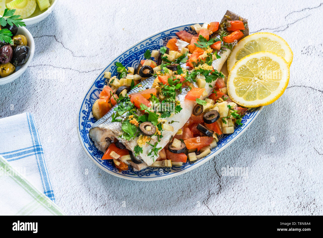 Mare Mediterraneo bass farcite con i pomodori, i limoni, il finocchio e le olive - vista dall'alto. La cucina greca. Foto Stock