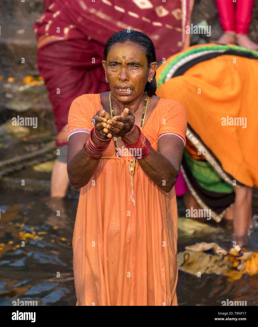 La donna esegue il rituale puja preghiera nel fiume Gange, Varanasi, India Foto Stock