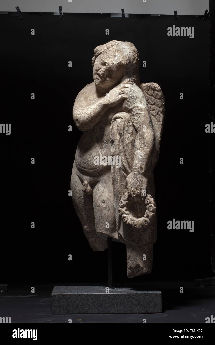 Un Romano Hymenaeus, fine del II secolo D.C. in marmo bianco con patina di età. La figura di un ragazzo in piedi con le ali, appoggiato ad una colonna drappeggiati con un cappotto con la sua spalla sinistra e la sua testa, tenendo un fogliame corona nella mano sinistra. Numerosi urti e piccole imperfezioni, le gambe dalle ginocchia verso il basso sono mancanti. Montato su un piedistallo contemporanea. Altezza senza stand 91 cm, peso circa 130 kg. Provenienza: Collezione privata dal sud della Germania, acquisita nel commercio di opere d' arte a Vienna nel 1979. storica, storica, Impero Romano, il mondo antico, Additional-Rights-Clearance-Info-Not-Available Foto Stock