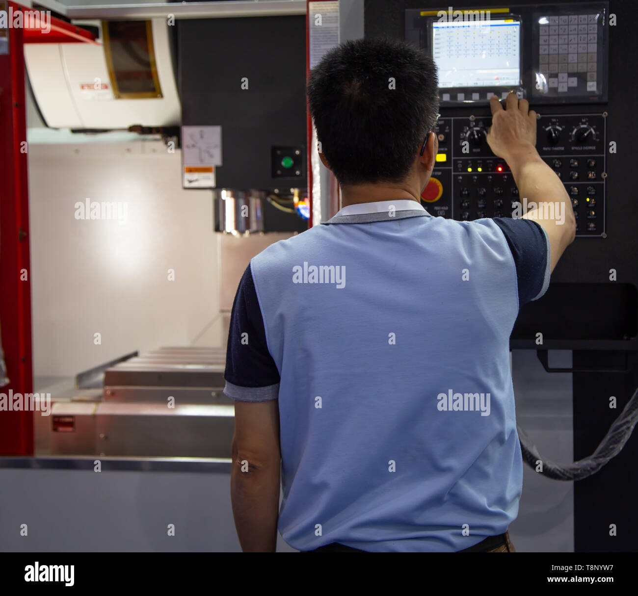 Operaio industriale i dati di ingresso per il funzionamento macchina CNC Foto Stock