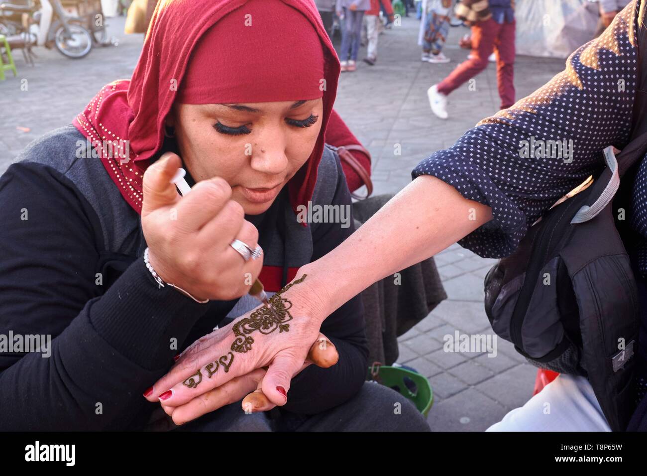 Il Marocco, Alto Atlante, Marrakech città imperiale, medina elencati come patrimonio mondiale dall' UNESCO, Piazza Jemaa El Fna, donna tinti a mano con henné Foto Stock