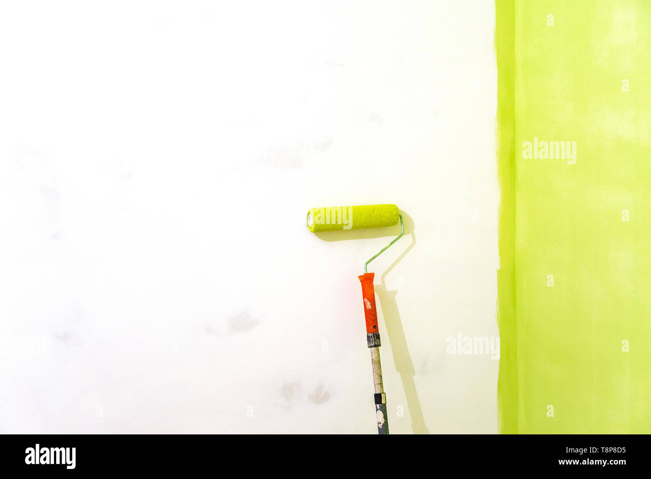 Pittura murale di colore verde e spazio di copia. Verniciatura di un muro di casa con una vernice a rullo. Foto Stock