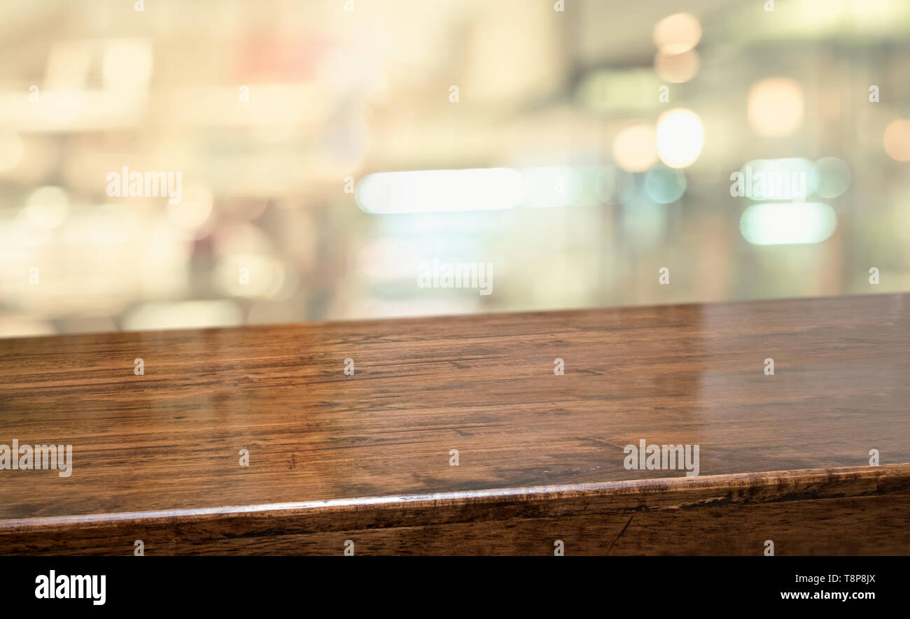 Tavola di legno al ristorante blur sullo sfondo.Empty prospettiva barra di legno duro con blur coffee shop con bokeh luce,Mock up per visualizzare o montaggio di produ Foto Stock
