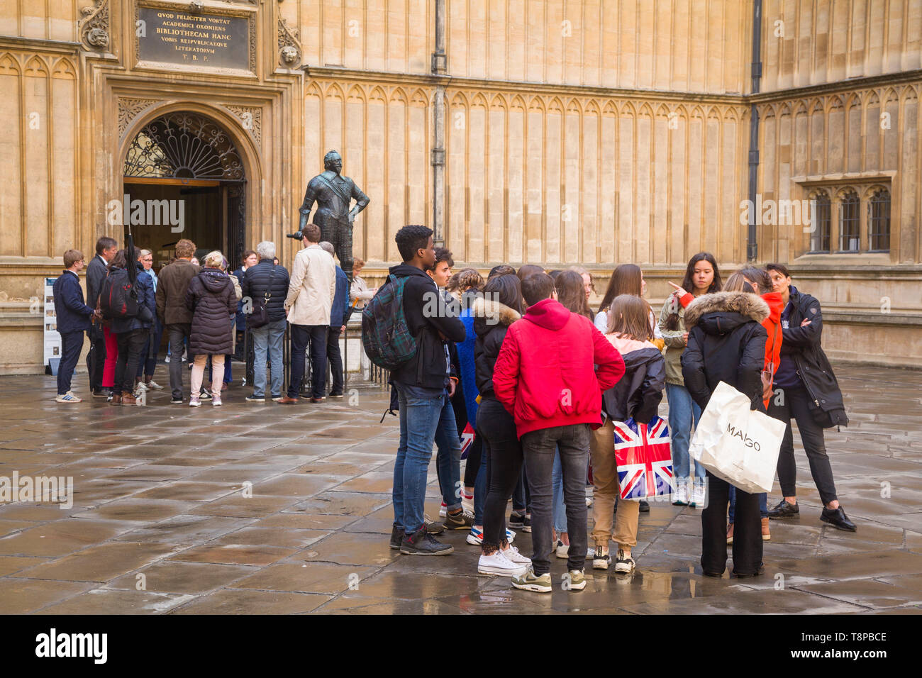 Due parti di scolari nella vecchia scuola Quad fuori la Libreria di Bodleian, Oxford Foto Stock