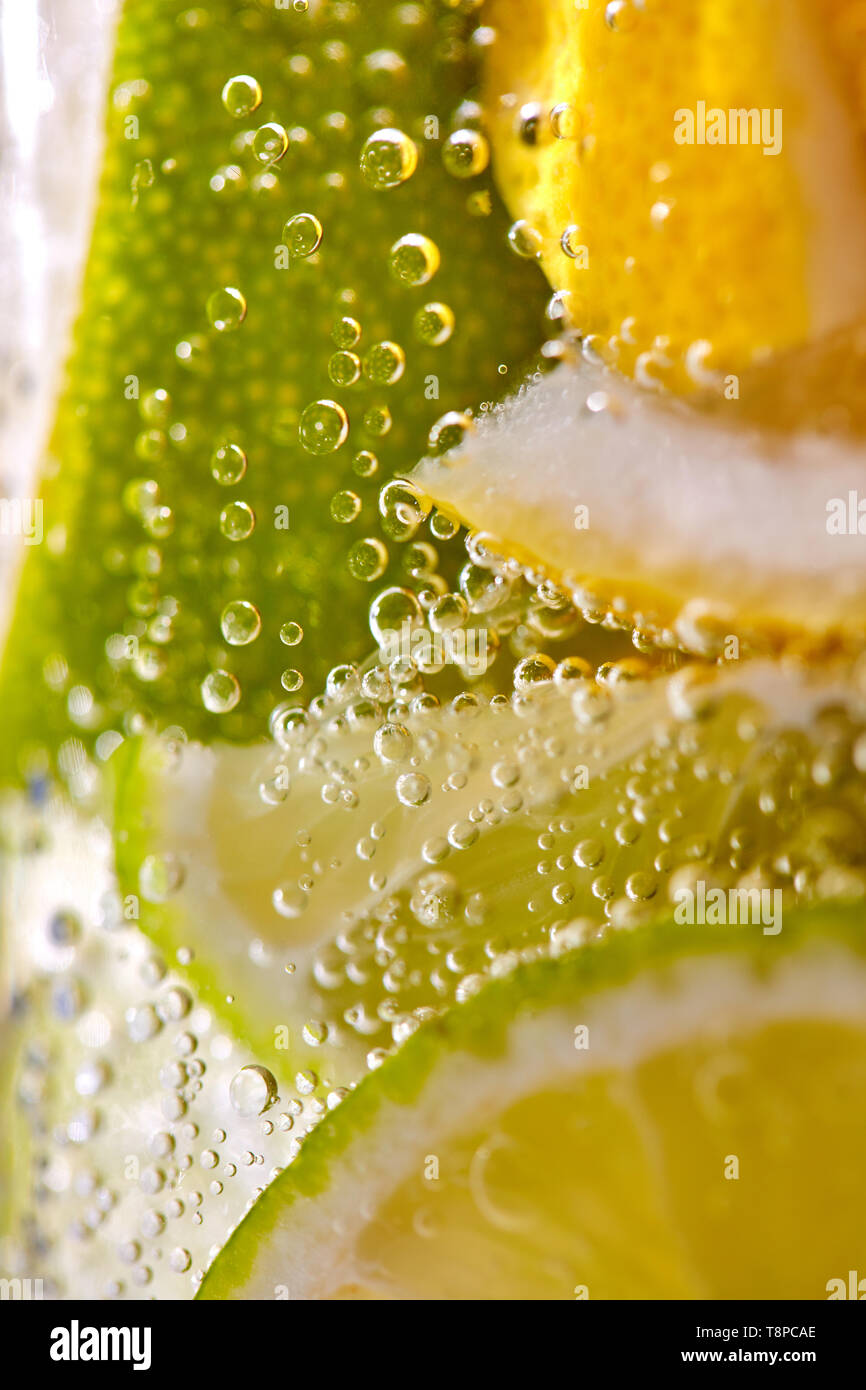 Foto macro di appena fatto limonata con pezzi di calce, limone e bolle in un bicchiere. Estate bevanda rinfrescante Foto Stock