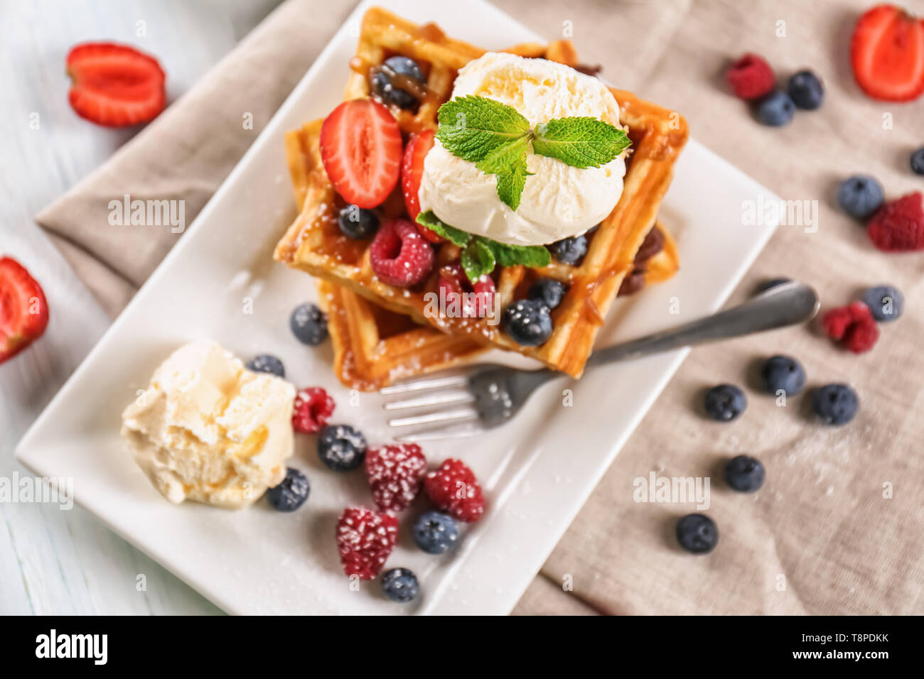 Deliziosi waffles con frutti di bosco e gelato su piastra Foto Stock