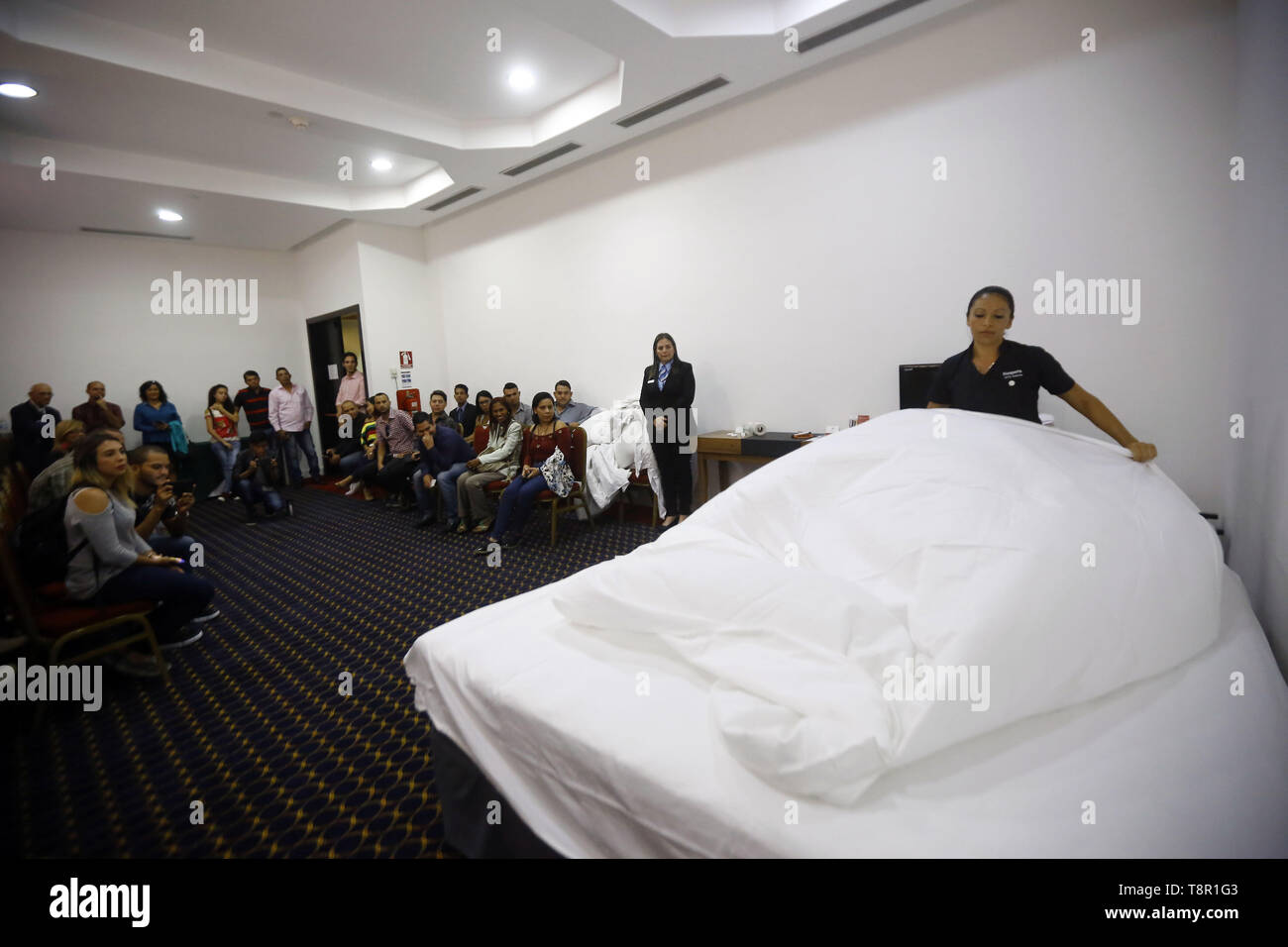 Valencia, Carabobo, Venezuela. 14 Maggio, 2019. Maggio 14, 2019. Dimostrazione di til opera di una cameriera, quando la medicazione il letto in occasione della cerimonia di apertura del centro Ibero-americana di studi superiori nel settore turistico e alberghiero, che ospiterà le strutture dell'Hesperia hotel in Valencia, in Carabobo. Foto: Juan Carlos Hernandez Credito: Juan Carlos Hernandez/ZUMA filo/Alamy Live News Foto Stock