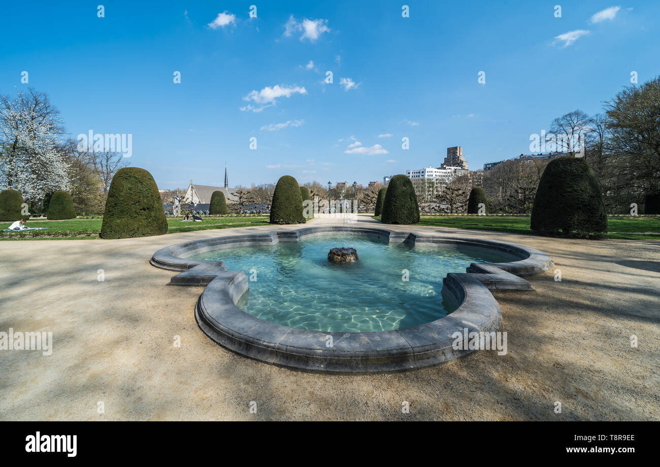 Ixelles, Bruxelles / Belgio - 03 30 2019: Panoramica ultra ampia vista sulla fontana al parco del La Cambre Abbazia durante una soleggiata giornata di primavera Foto Stock