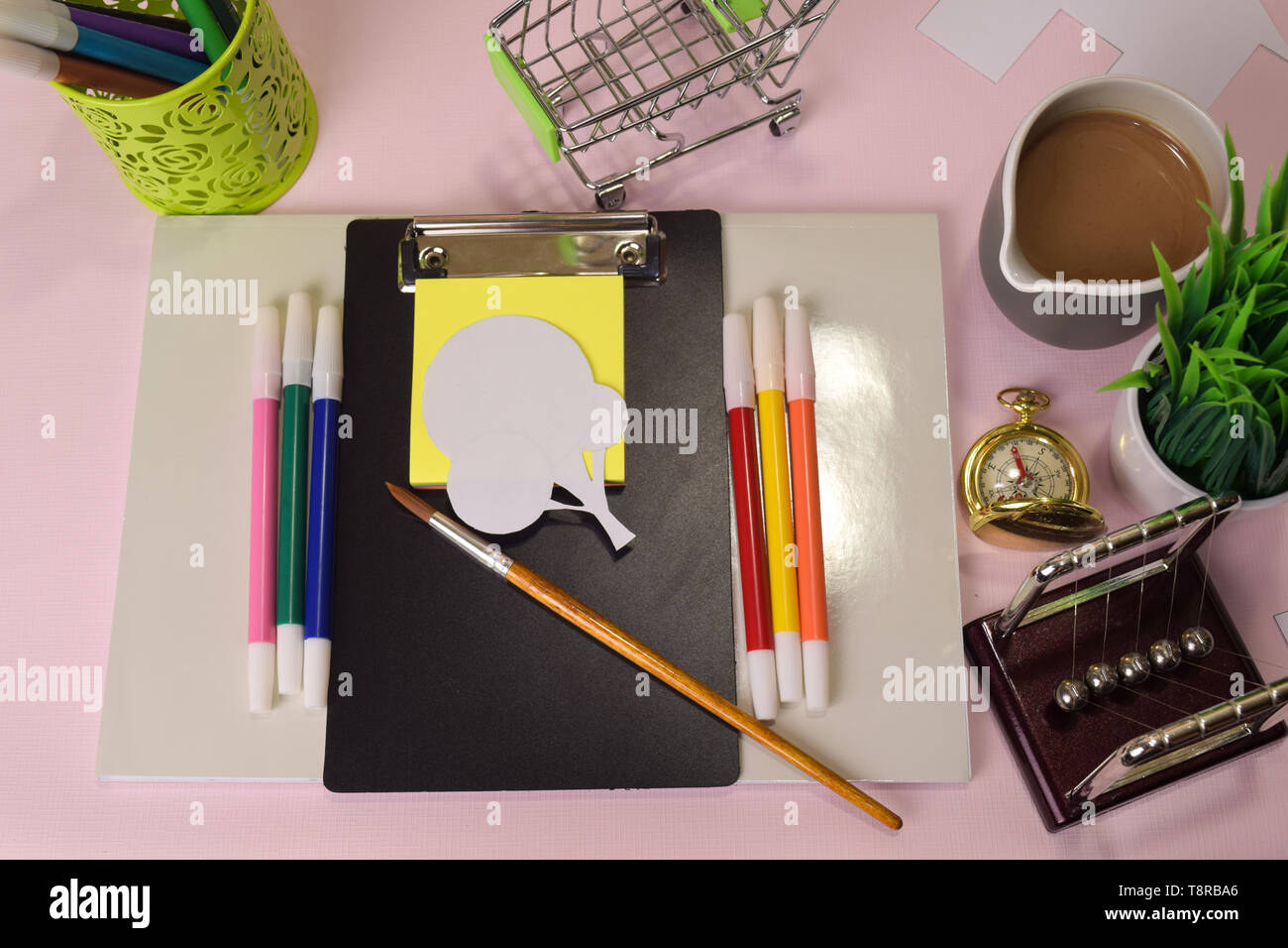 Vista superiore del taglio di carta illustrazione un alberi su una tabella di colore rosa, preparando a fare i compiti in un blocco appunti. Disegno Scrivania Concept Foto Stock