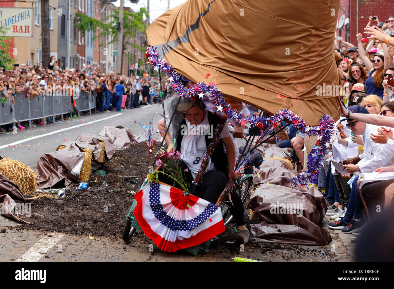 Un partecipante si alza dopo la loro arte bicicletta crolla al termine di pozzo del fango sfida nel 2019 Kensington scultura cinetica Derby di Philadelphia, Foto Stock