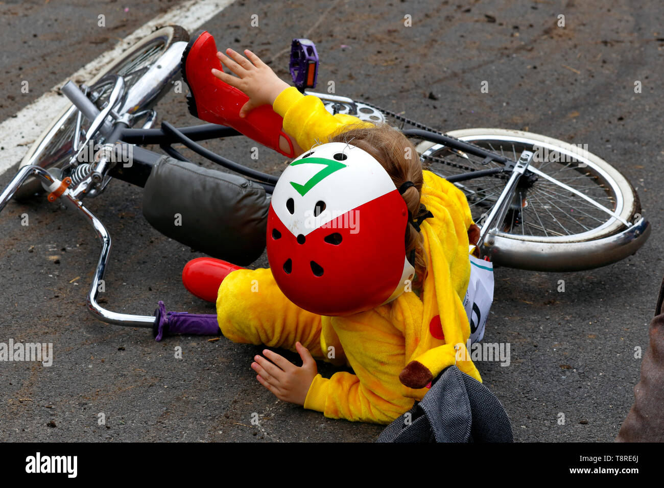 Un bambino cade da una bicicletta al traguardo del 2019 Scultura Kensington Derby Foto Stock