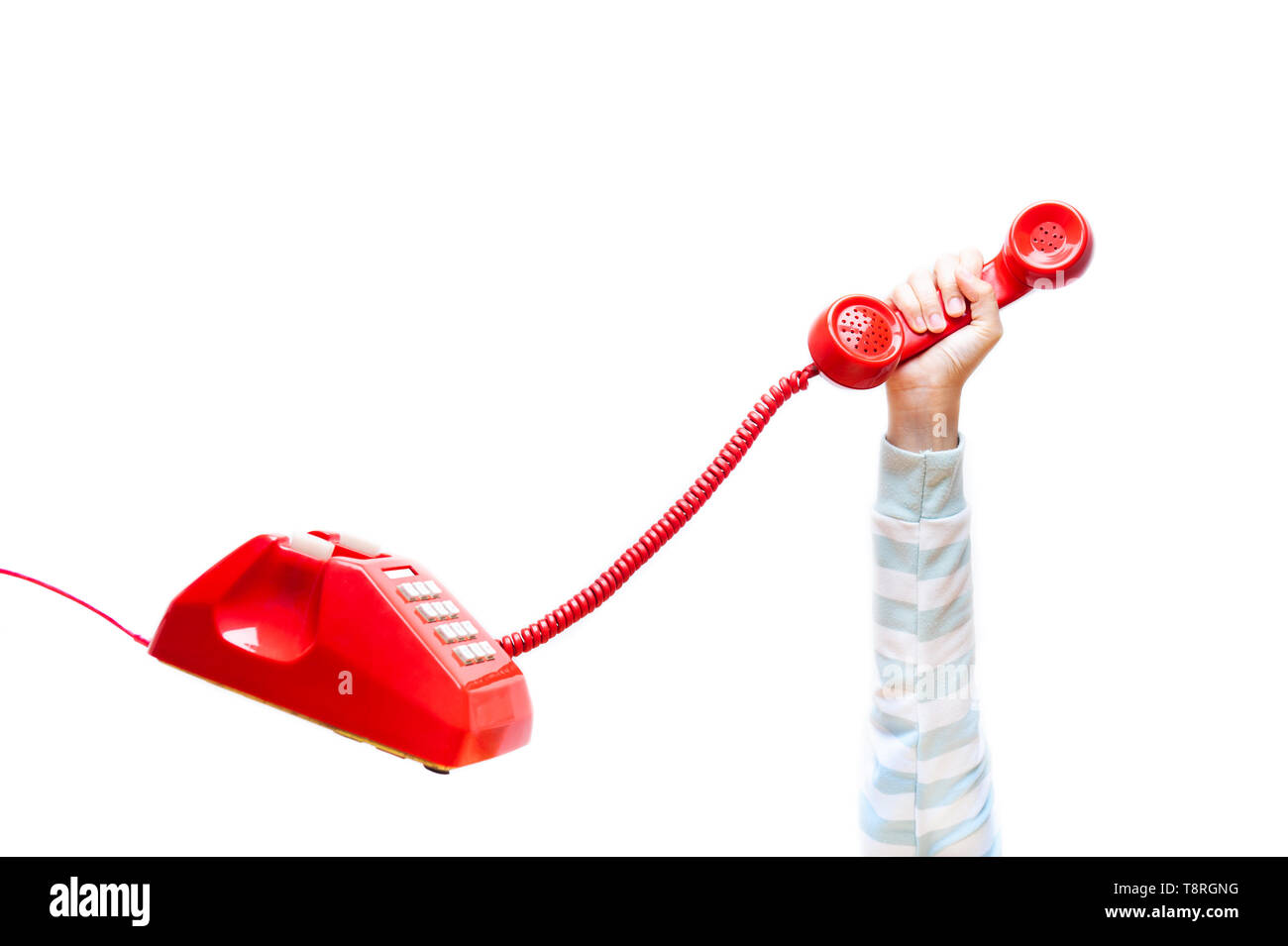 Mano azienda telefonica, il braccio che indossa un maglione, rosso classico ricevitore telefonico, vecchio telefono isolato su sfondo bianco in volo in assenza di peso. C Foto Stock