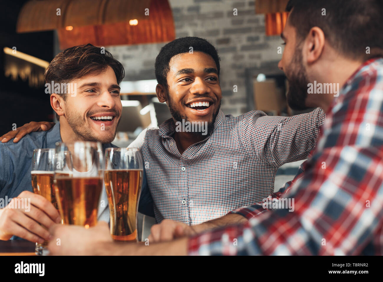 La condivisione di news. Diversi gli amici a bere la birra nel bar Foto Stock