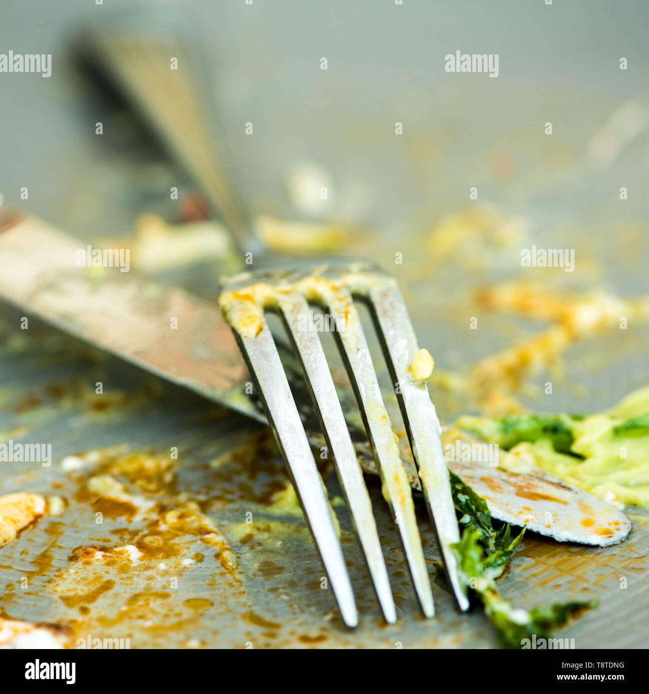 Sporco coltello e forchetta su una piastra a vuoto dopo un pasto Foto Stock