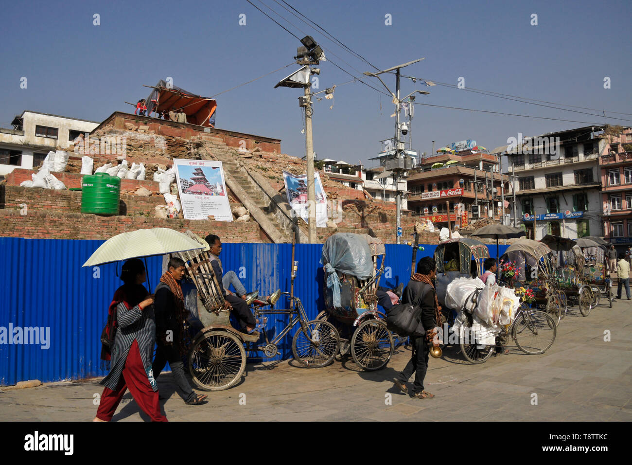 Pedicabs attendono i clienti vicino al restauro di Maju Dewal, distrutto nel 2015 Terremoto, Durbar Square, Kathmandu, Nepal Foto Stock