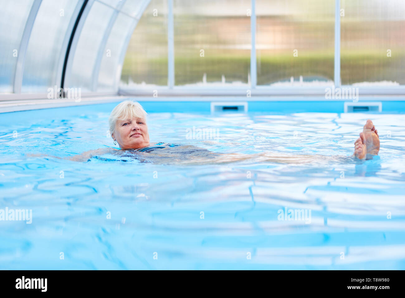 Senior donna fanno rehab dorso nella piscina di idroterapia Foto Stock
