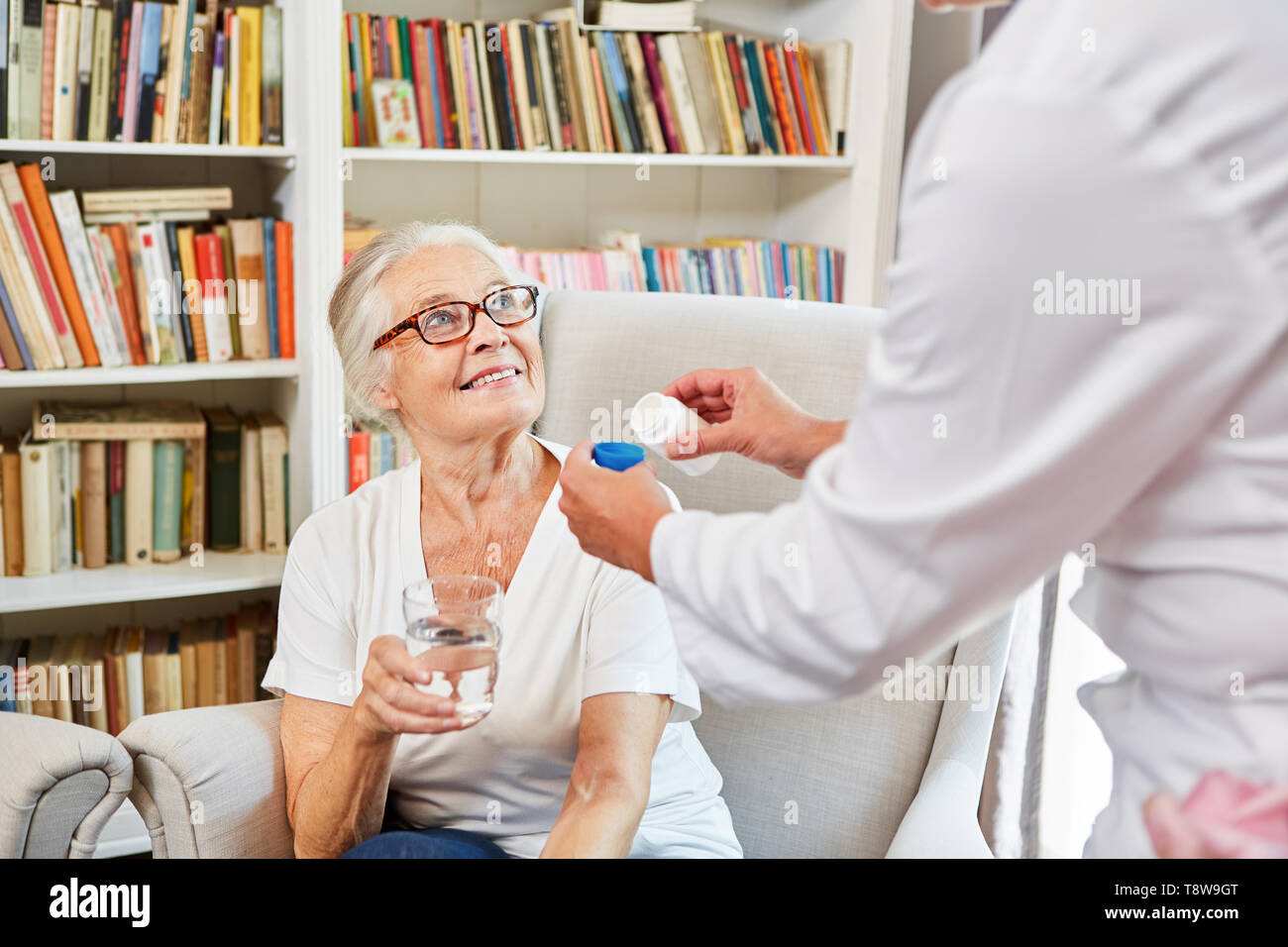 L'infermiera distribuisce il farmaco al senior donna in condizioni di vita assistita Foto Stock