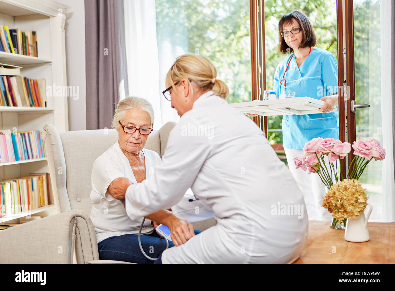 Il medico e l'infermiera geriatrica prendersi cura degli anziani nella senior residence Foto Stock
