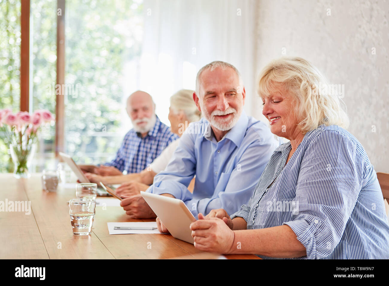 Seniors divertirsi imparando insieme nel corso di computer presso la casa di riposo Foto Stock