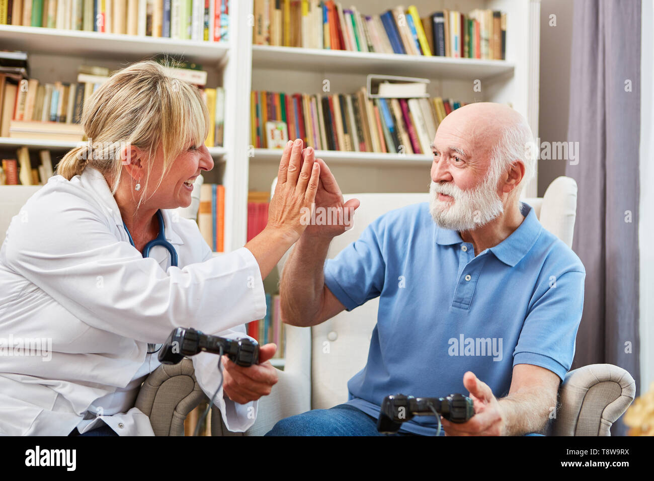 Medico donna e uomo senior ottenere insieme per un video gioco di alta cinque Foto Stock