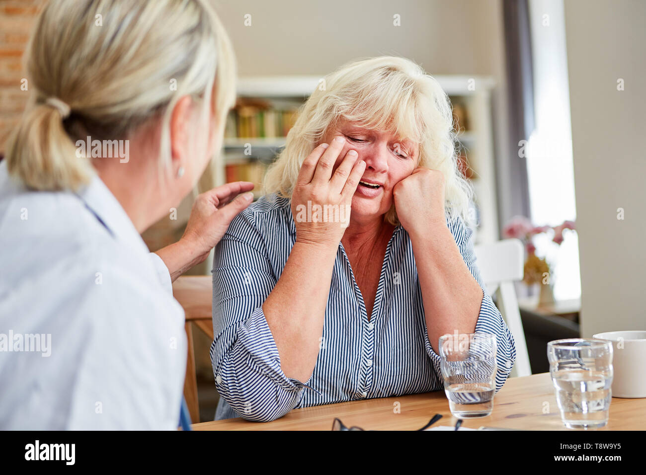 Servizio infermieristico donna o medico comfort del paziente di pianto durante la visita iniziale Foto Stock