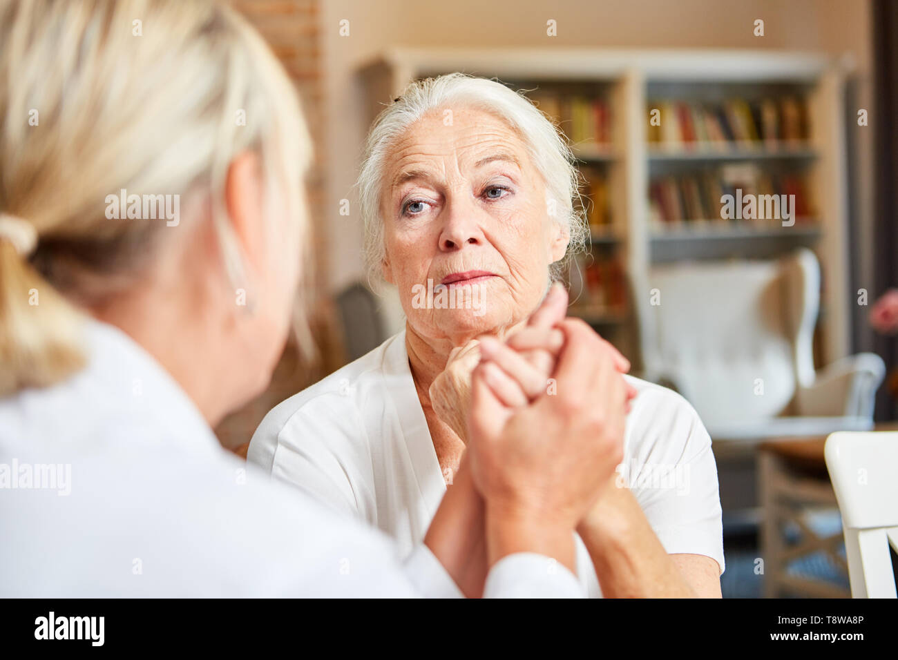 Premuto senior donna in consultazione con il suo medico donna o terapista Foto Stock