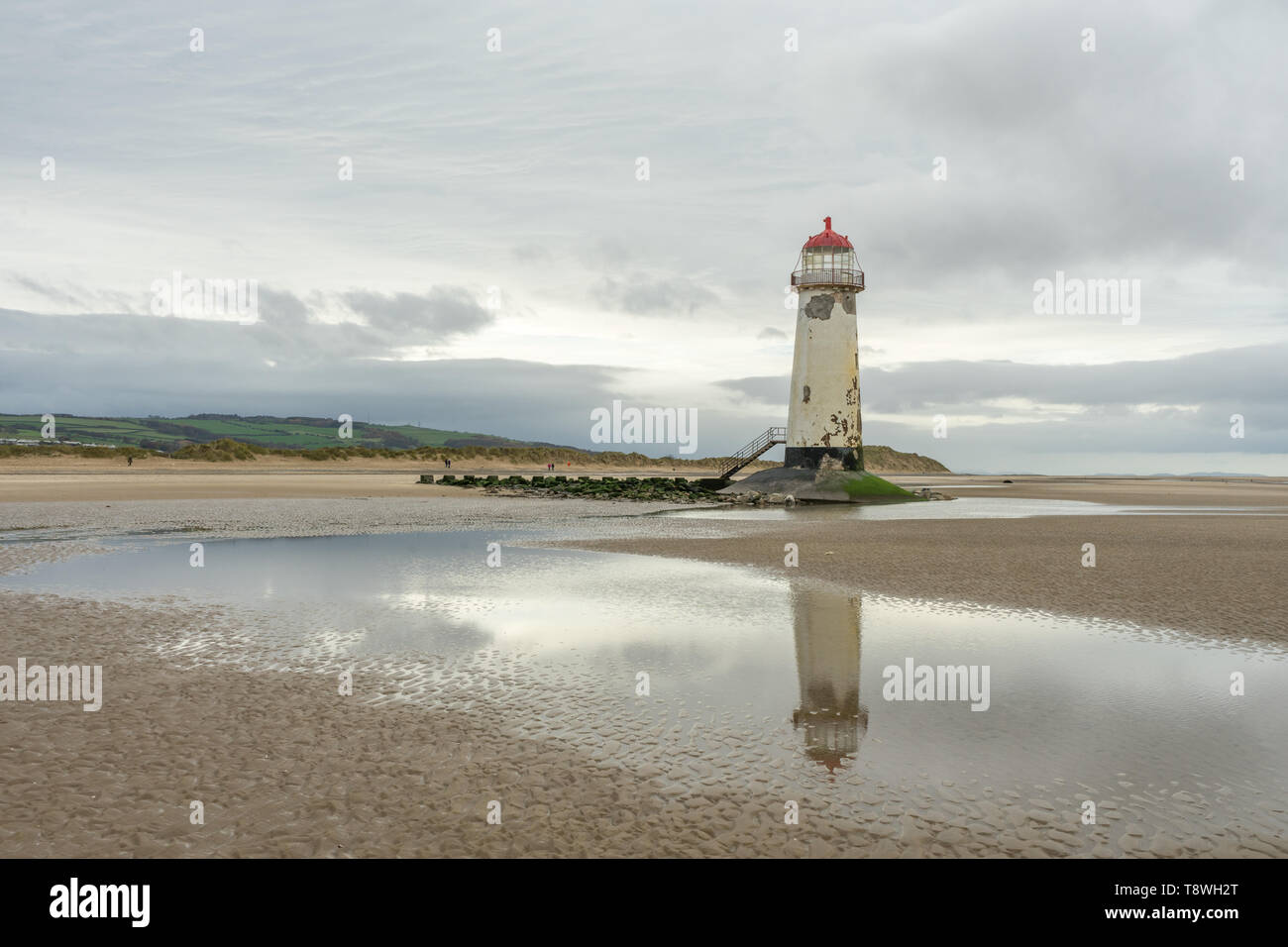 Faro sul mare con riflesso nell'acqua in corrispondenza del punto di Ayr in Galles del Nord, Regno Unito Foto Stock