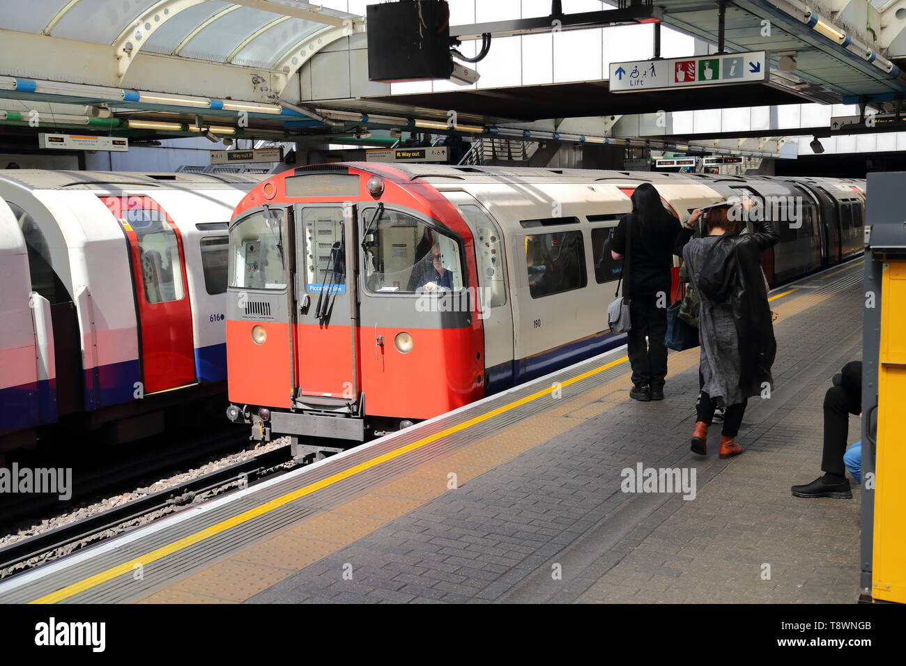 La Metropolitana arriva alla fermata della metropolitana di Hammersmith, London, Regno Unito Foto Stock