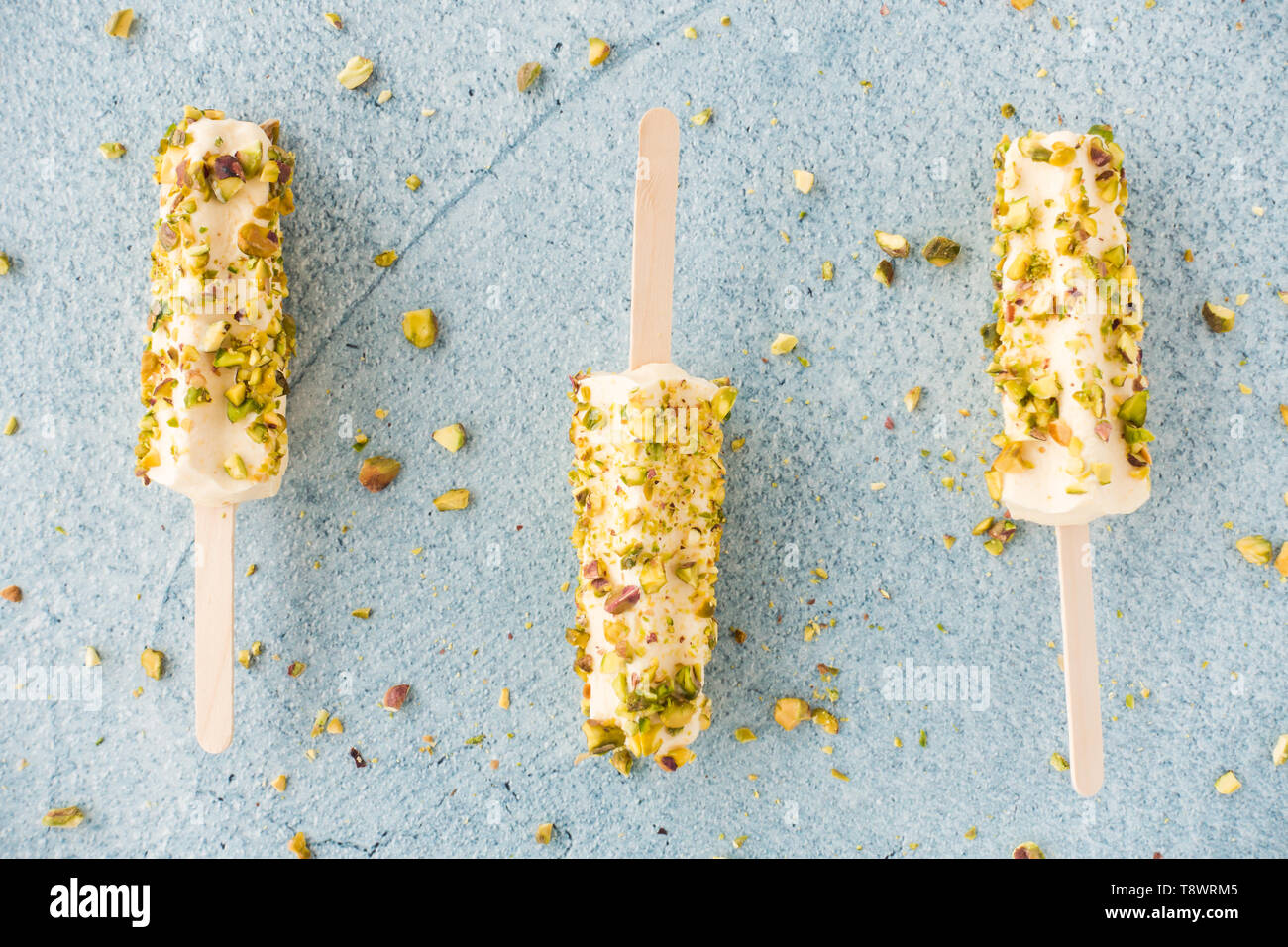 Primo piano del casalingo e mango kulfi pistacchio lollies blu su sfondo di cemento. Vista dall'alto. Foto Stock