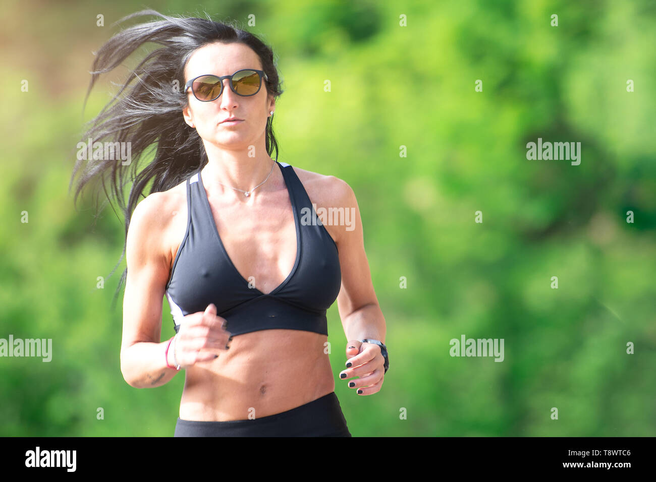Sportivo da donna corre in natura dopo una giornata stressante in ufficio Foto Stock