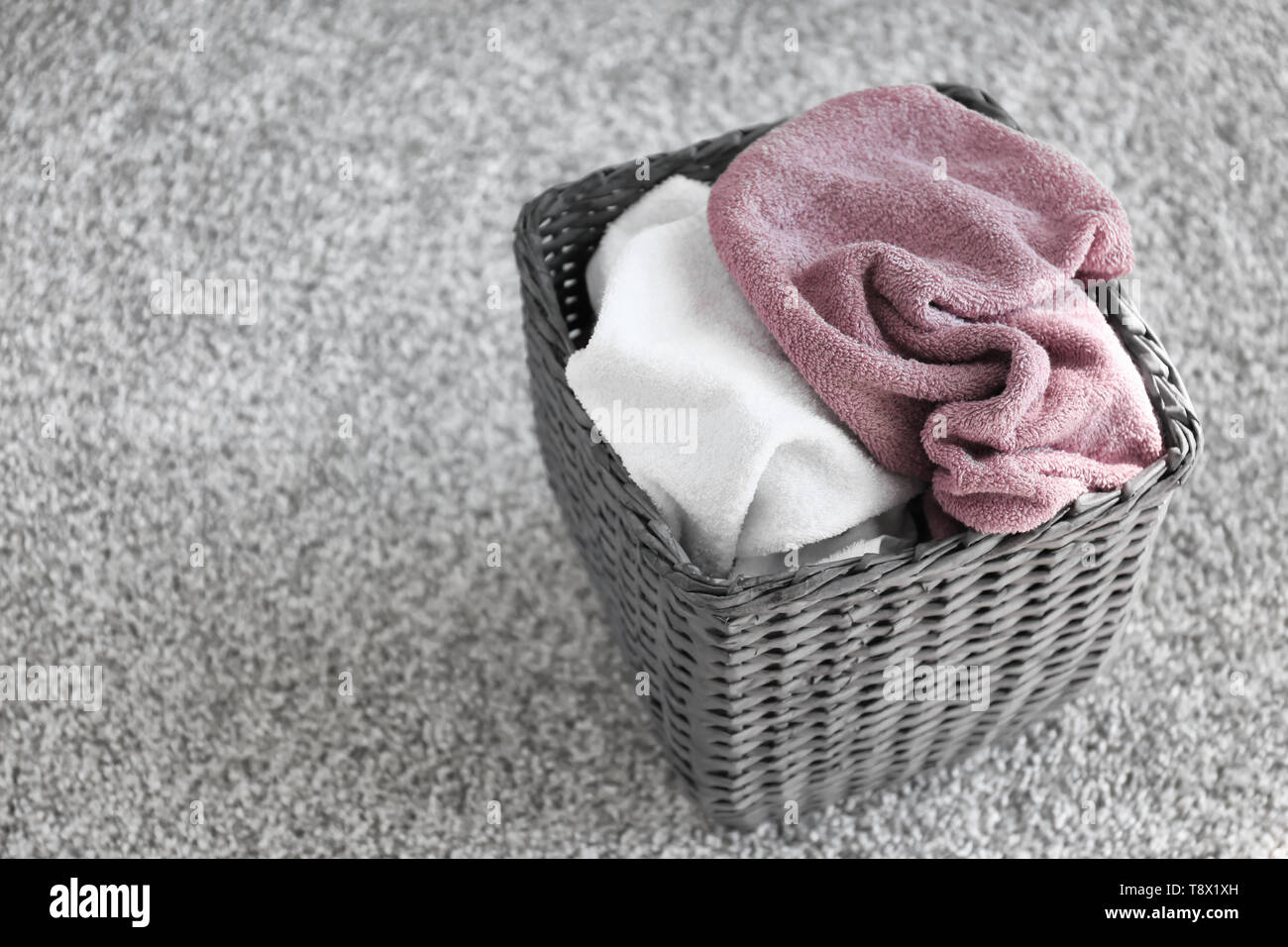 Servizio lavanderia cesto con asciugamani sporchi sul pavimento Foto stock  - Alamy