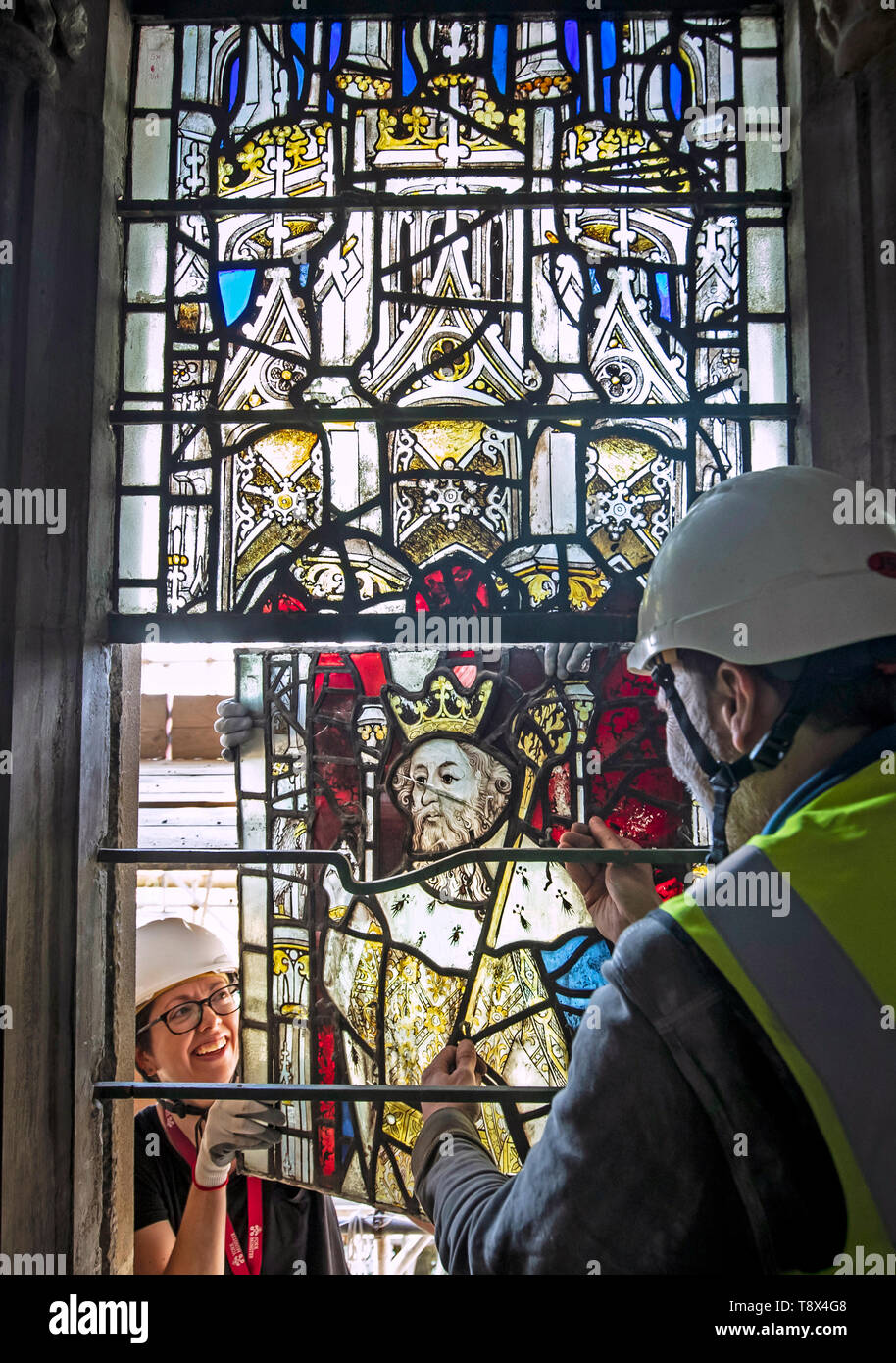 Conservazione manager Nick Tced (destra) e conservatore Zoe Harrigan (sinistra) staccare un vetro macchiato windows pannello durante la prima fase di lavoro per proteggere 600-anno-vecchio le finestre di vetro macchiate a York Minster. Il lavoro è parte di un anno 11, £11m di conservazione e restauro della cattedrale. Foto Stock
