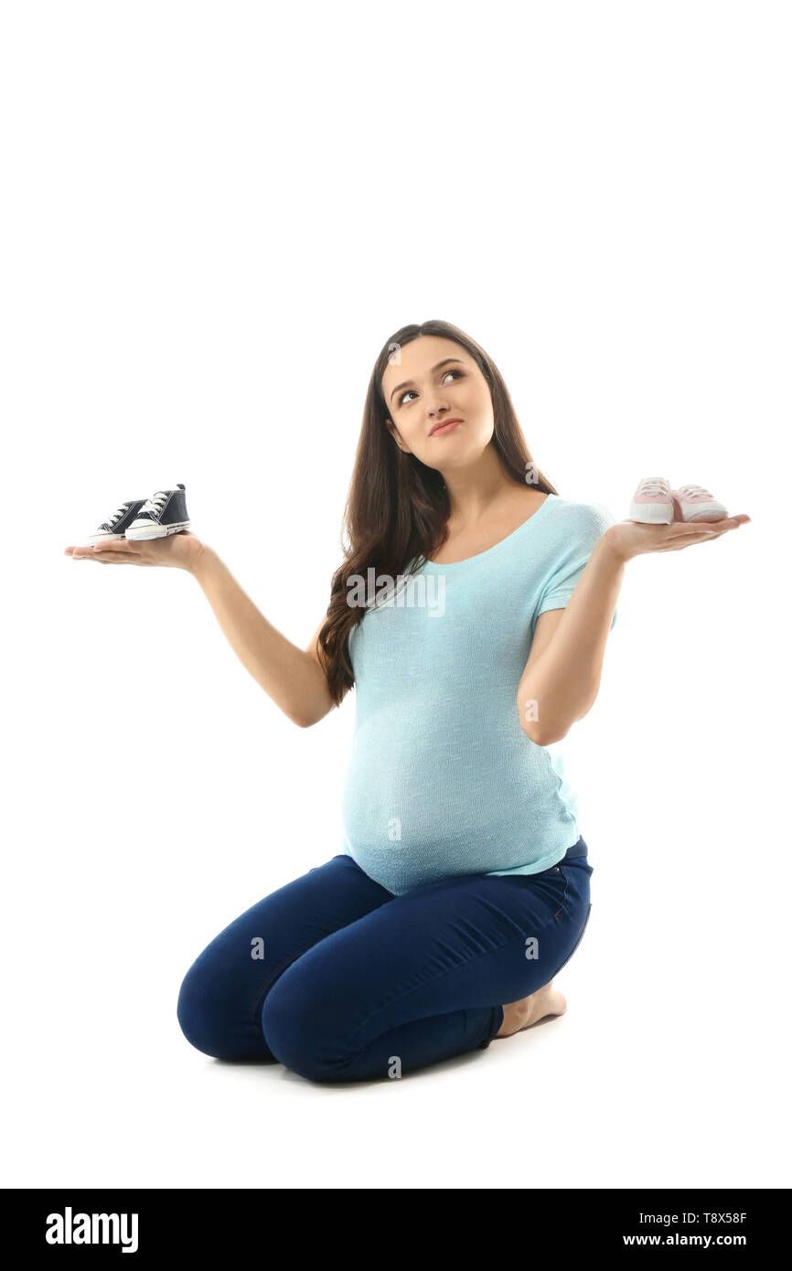 Bella donna incinta con girlish e fanciullesco babbucce su sfondo bianco Foto Stock