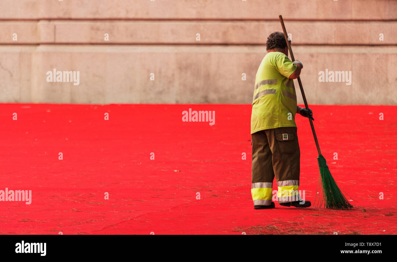 L'uomo spazzare un tappeto rosso in porto Foto Stock