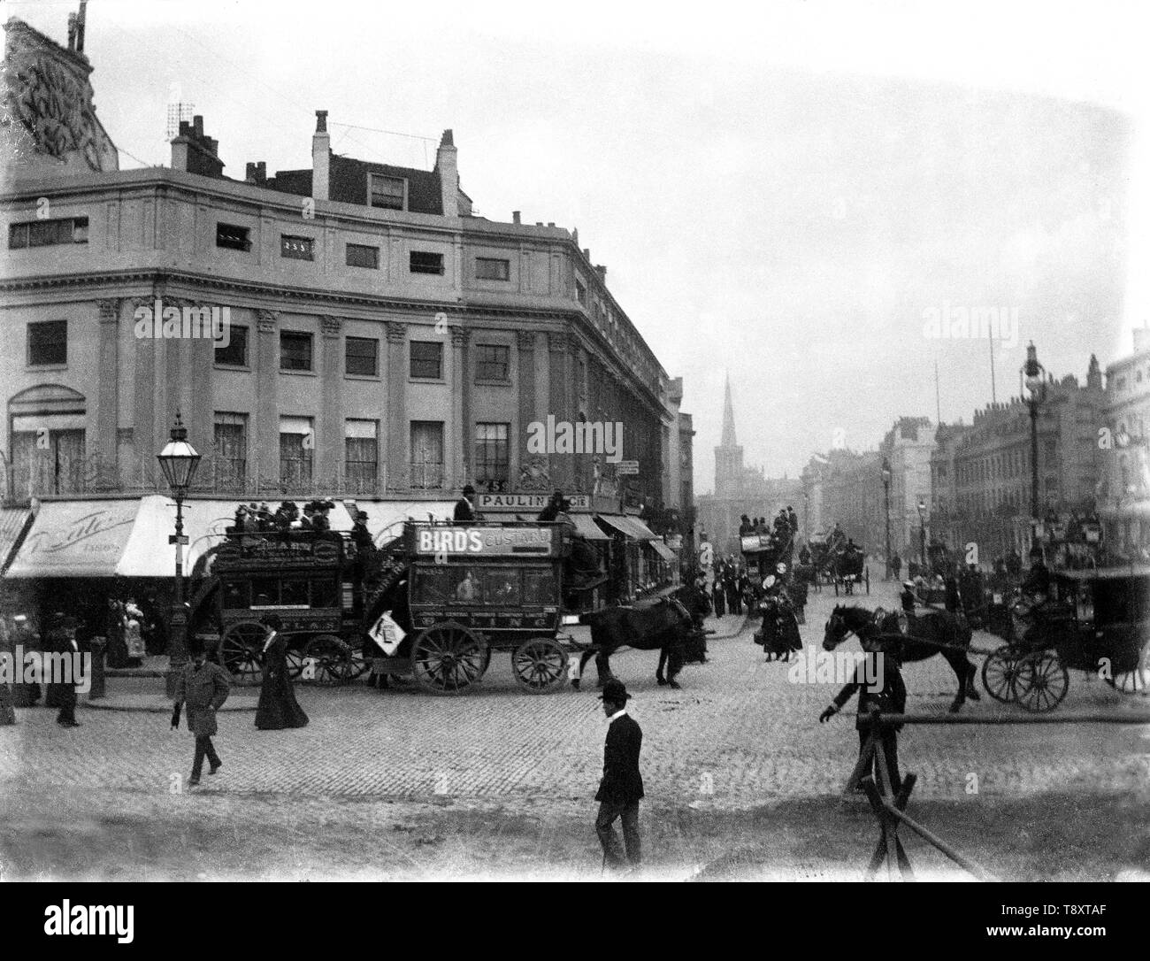 Oxford Circus Victorian London street scene del cavallo e gli autobus e gli altri veicoli e le persone che si recano sulle loro attività quotidiane con una goccia di negozi a baldacchino e tutte le anime chiesa nella distanza. c1900 Foto dal interamente di proprietà di vetro di originale della piastra di raccolta negativa da Tony Henshaw Foto Stock