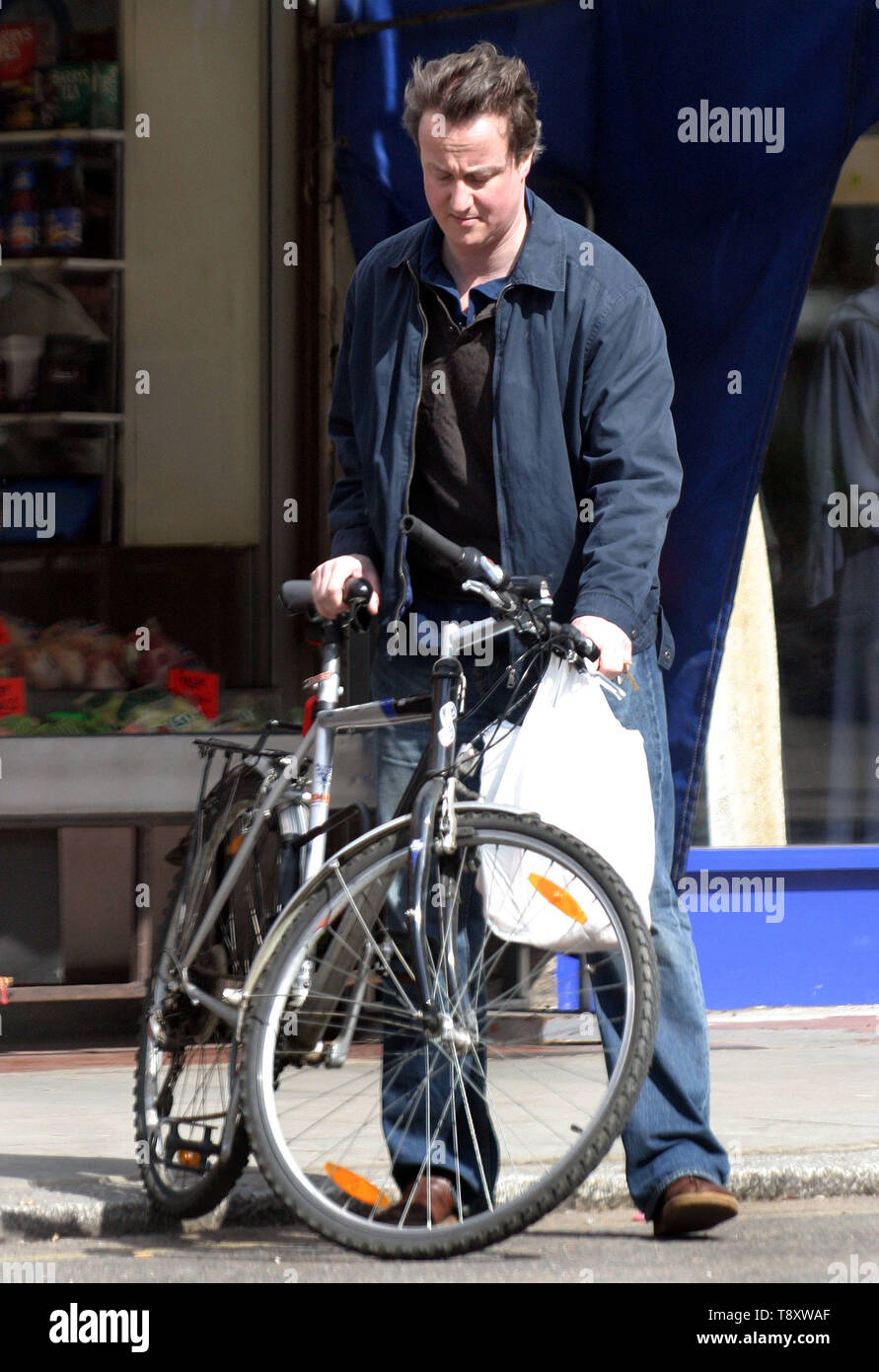 David Cameron è chiaramente un uomo della sua parola come egli usa la sua moto per fare la famiglia a fare la spesa presso i suoi negozi locali. Chiaramente non è per il sig. Cameron è il 'celebrità stile' supermercato consegne di stile come il 'moderne man' carichi la sua bicicletta in un vero sinistra/destra bilanciamento atto come egli ruotata a destra di fronte un juuggernaut! La prossima volta forse un insieme di ciclismo ingranaggio di sicurezza potrebbe essere appropriato. Foto di Tony Henshaw Foto Stock