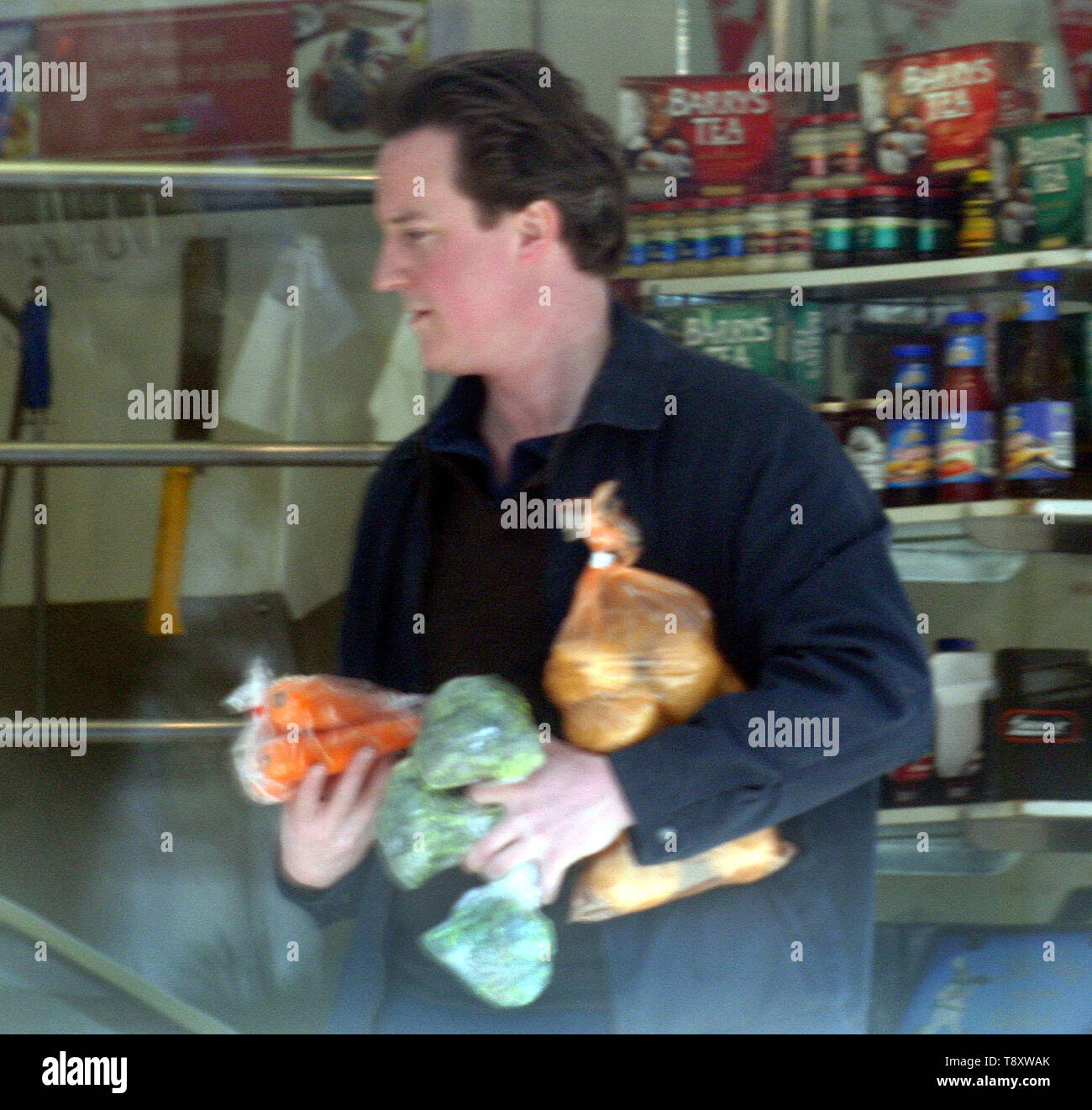 David Cameron è chiaramente un uomo della sua parola come egli usa la sua moto per fare la famiglia a fare la spesa presso i suoi negozi locali. Chiaramente non è per il sig. Cameron è il 'celebrità stile' supermercato consegne di stile come il 'moderne man' carichi la sua bicicletta in un vero sinistra/destra bilanciamento atto come egli ruotata a destra di fronte un juuggernaut! La prossima volta forse un insieme di ciclismo ingranaggio di sicurezza potrebbe essere appropriato. Foto di Tony Henshaw Foto Stock