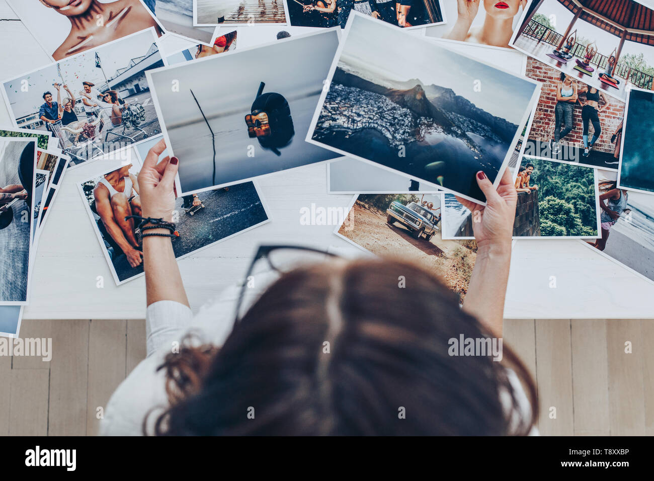 Vista dall'alto di una donna fotografa il lavoro in studio. Fotografo femmina Controllo immagine di stampa. Foto Stock