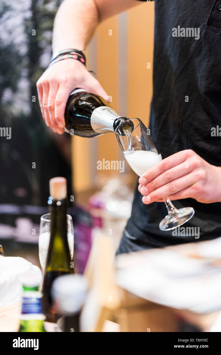 Un barman versando il vino spumante a un pop up bar in giardino Trebah in Cornovaglia. Foto Stock